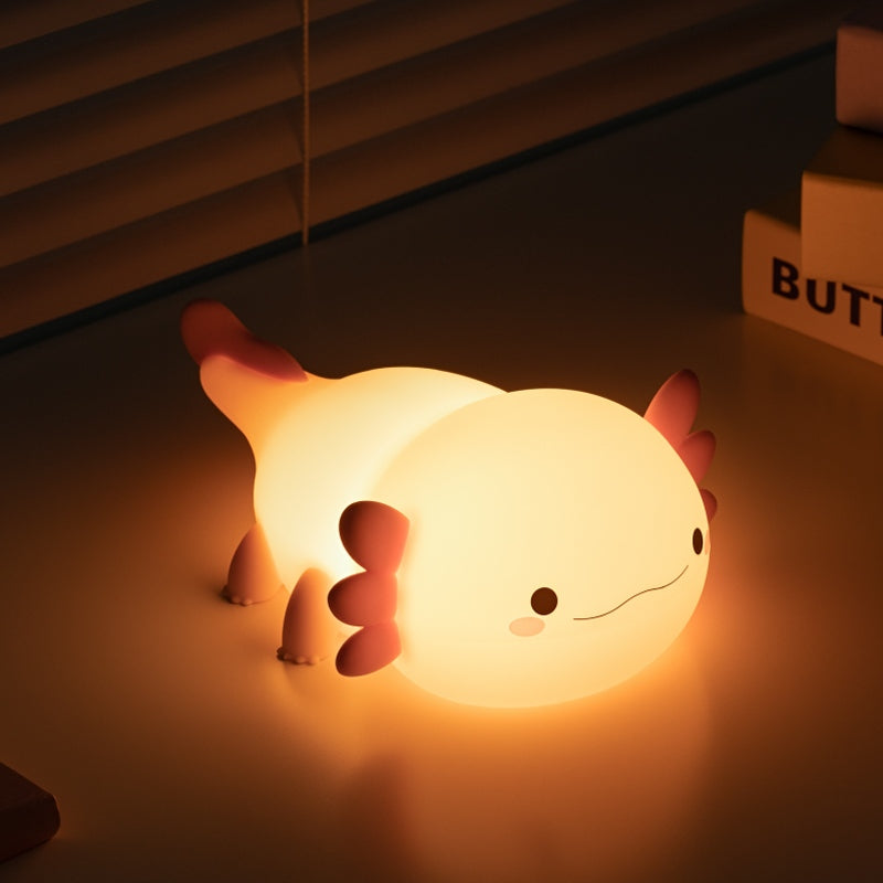 The UNEEJOY axolotl night light providing a gentle, warm glow in a dark room