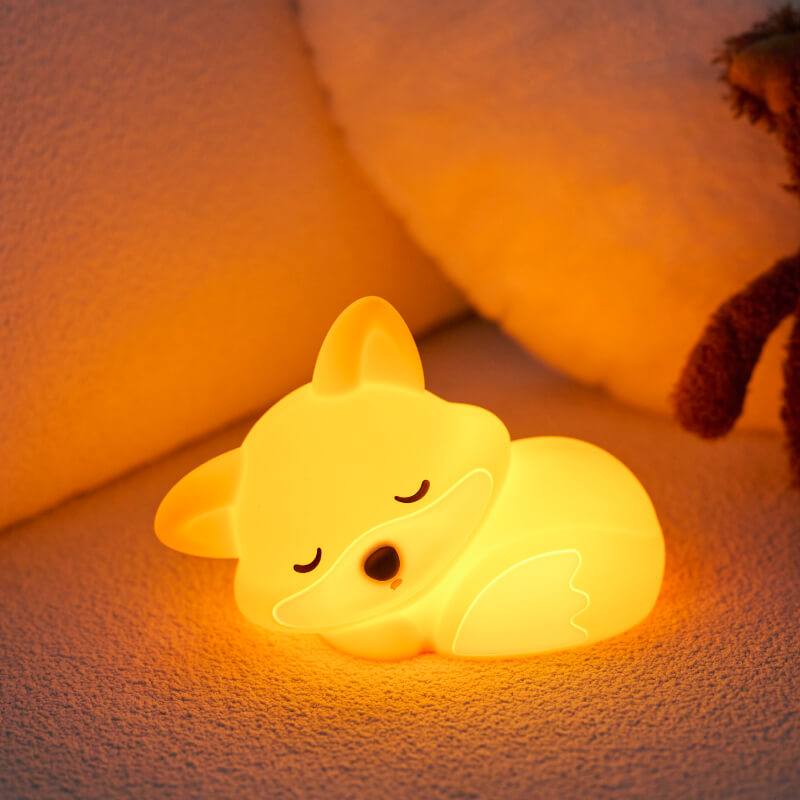 UNEEJOY cute fox night light glowing warmly next to a plush toy.